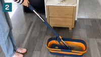 Rinsing the flat mop pad in the bucket rinse chamber on a timber-look floor